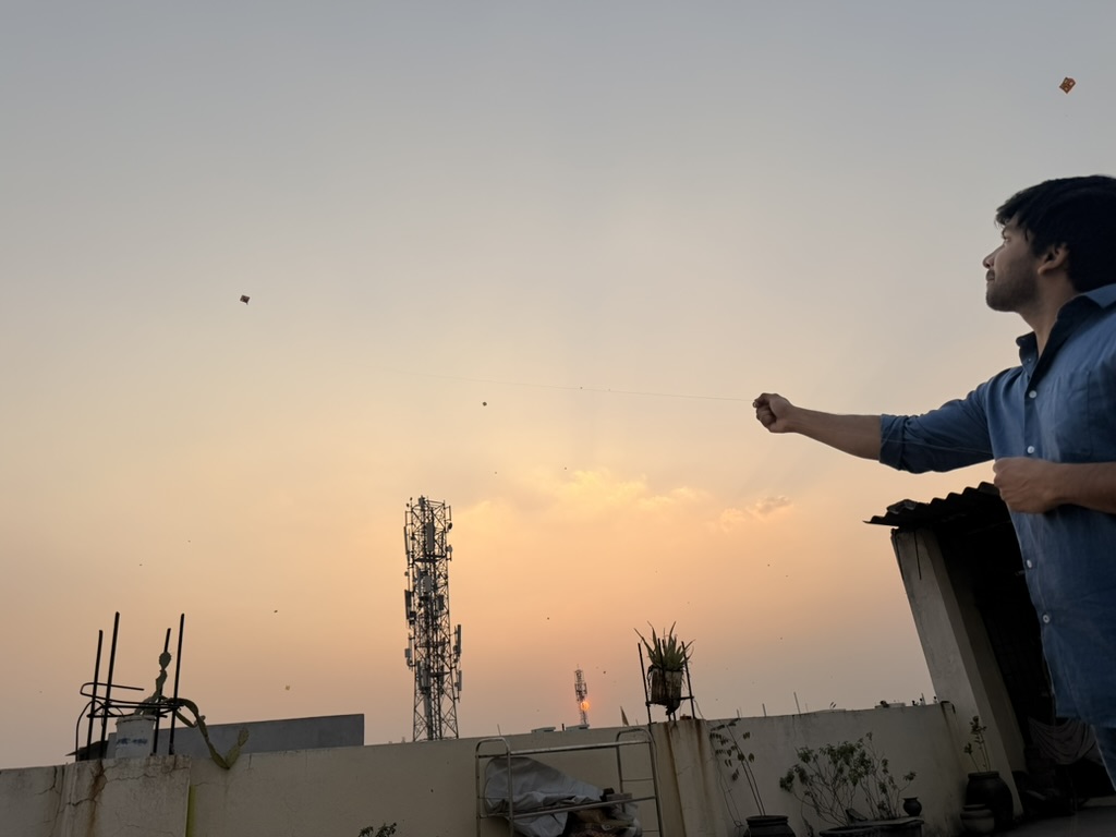 Flying a kite at sunset on a rooftop in Godavarikhani